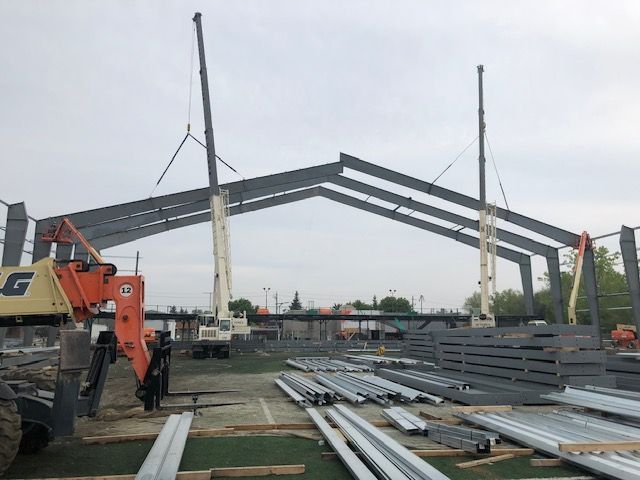 A large metal structure is being built on a construction site.