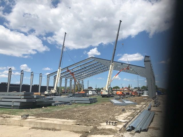 A large metal structure is being built with cranes.