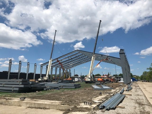 A large metal structure is being built with cranes.