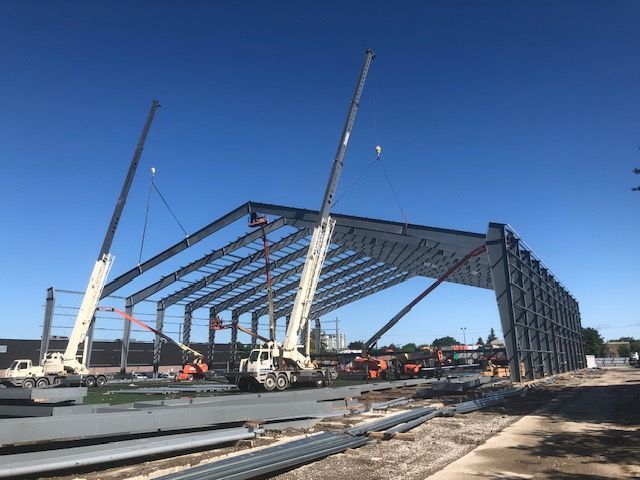 A large metal structure is being built with cranes.