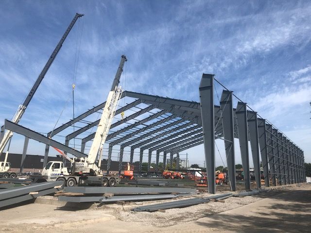 A large metal structure is being built with a crane.