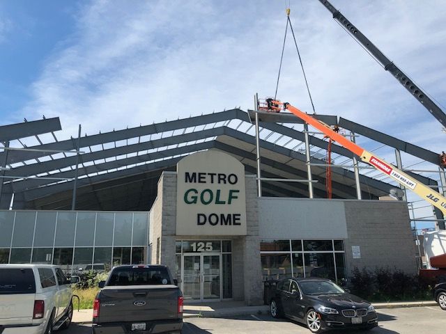 A building under construction with a sign that says metro golf dome