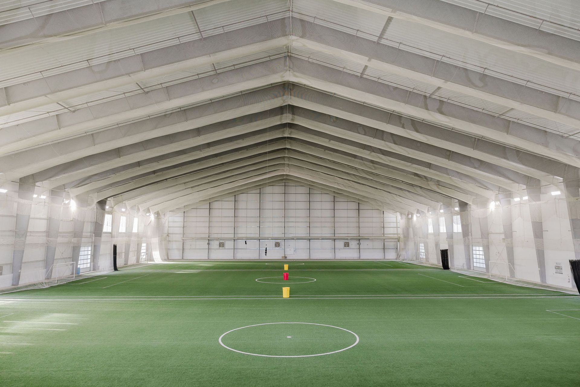 A large indoor soccer field with a circle in the middle of it.