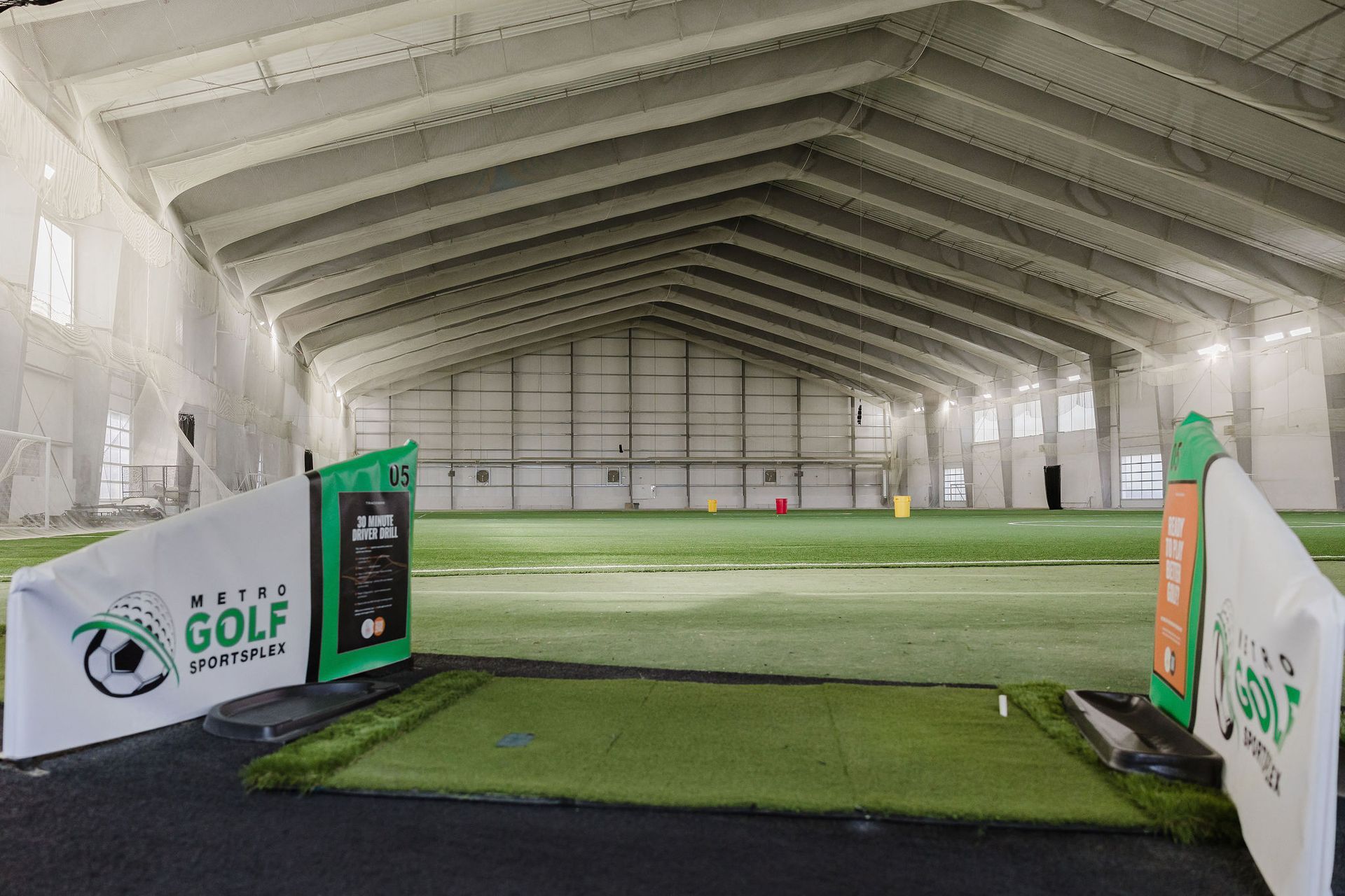 A large indoor golf course with a sign that says metro golf institute.