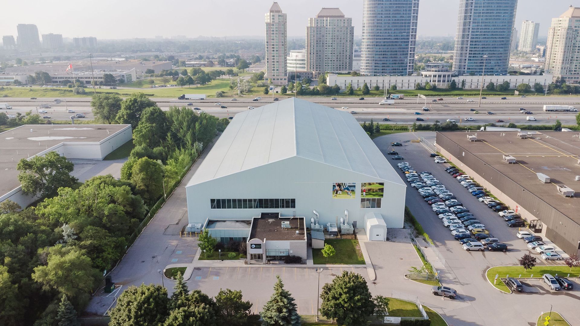 An aerial view of a large building with a lot of cars parked in front of it.