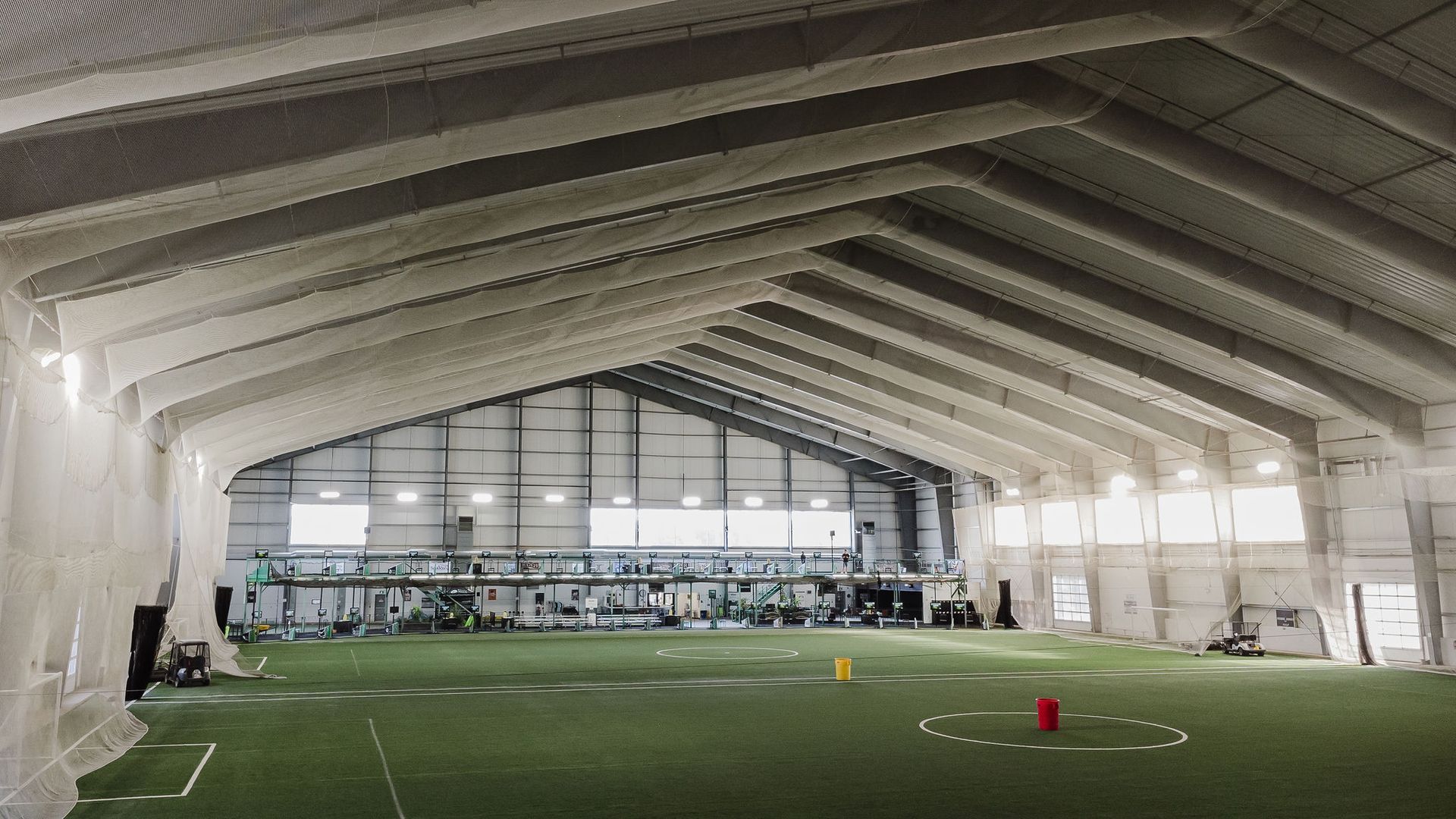 A large indoor stadium with a soccer field inside of it.