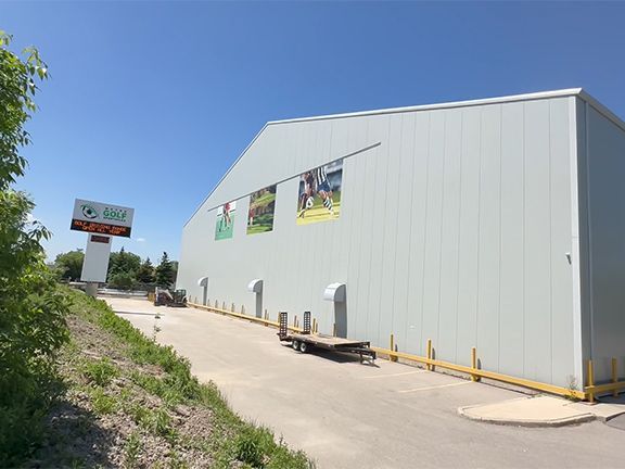 A large white building with a trailer parked in front of it.