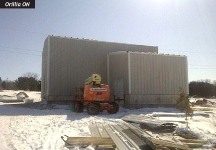 A jlg crane is parked in front of a building under construction