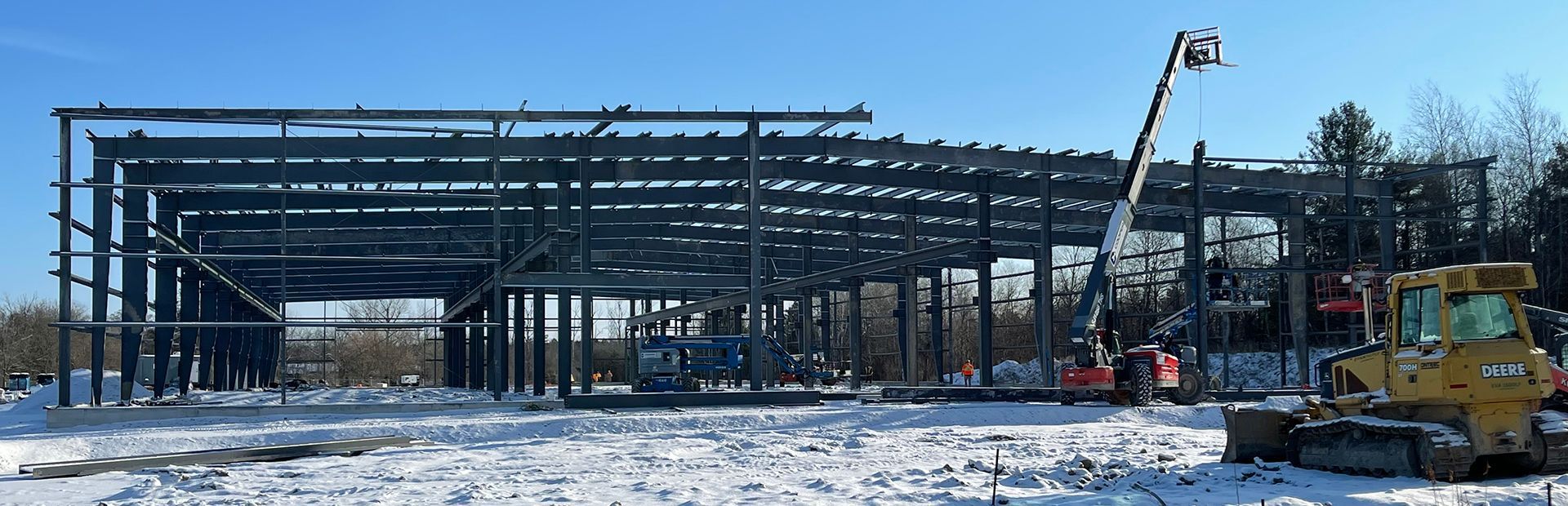A large metal structure is being built in the snow.