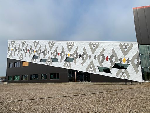 A large building with a geometric pattern on the side of it.