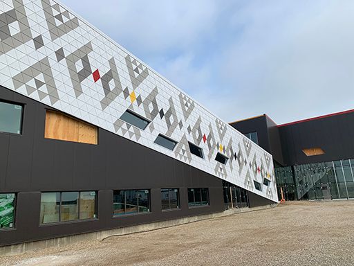 A large building with a geometric pattern on the side of it.