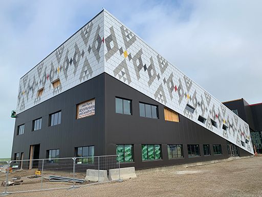 A large building with a fence around it is being built.