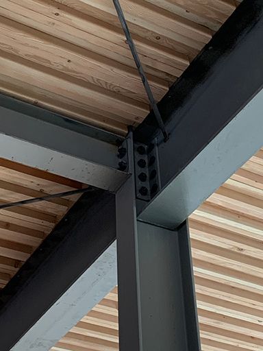 A close up of a metal structure with a wooden ceiling.