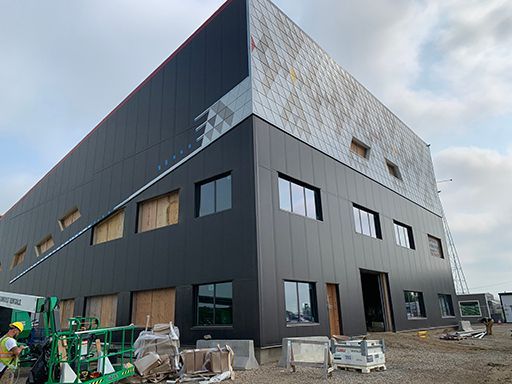 A large black building with a lot of windows is being built.