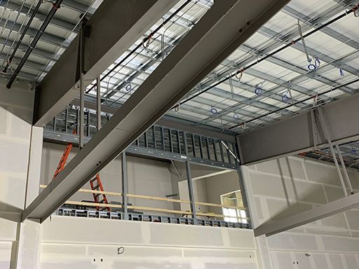 A large building under construction with a ladder hanging from the ceiling.