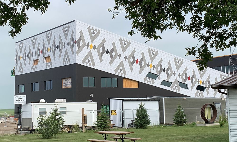 A large building with a First Nations design on the side of it.