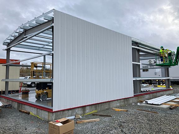 A man in a lift is working on a building under construction.