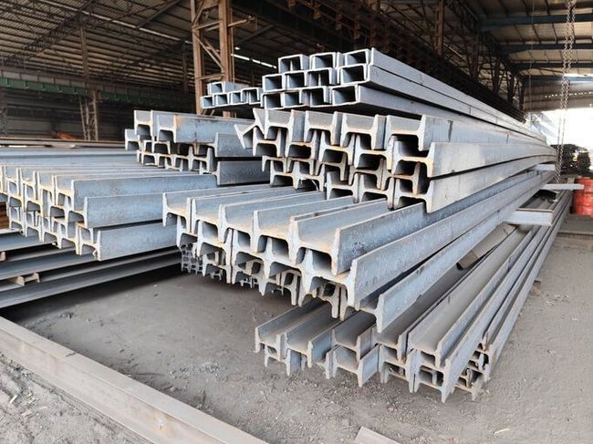 Stacked metal pipes and scaffolding tubes stored in a construction yard