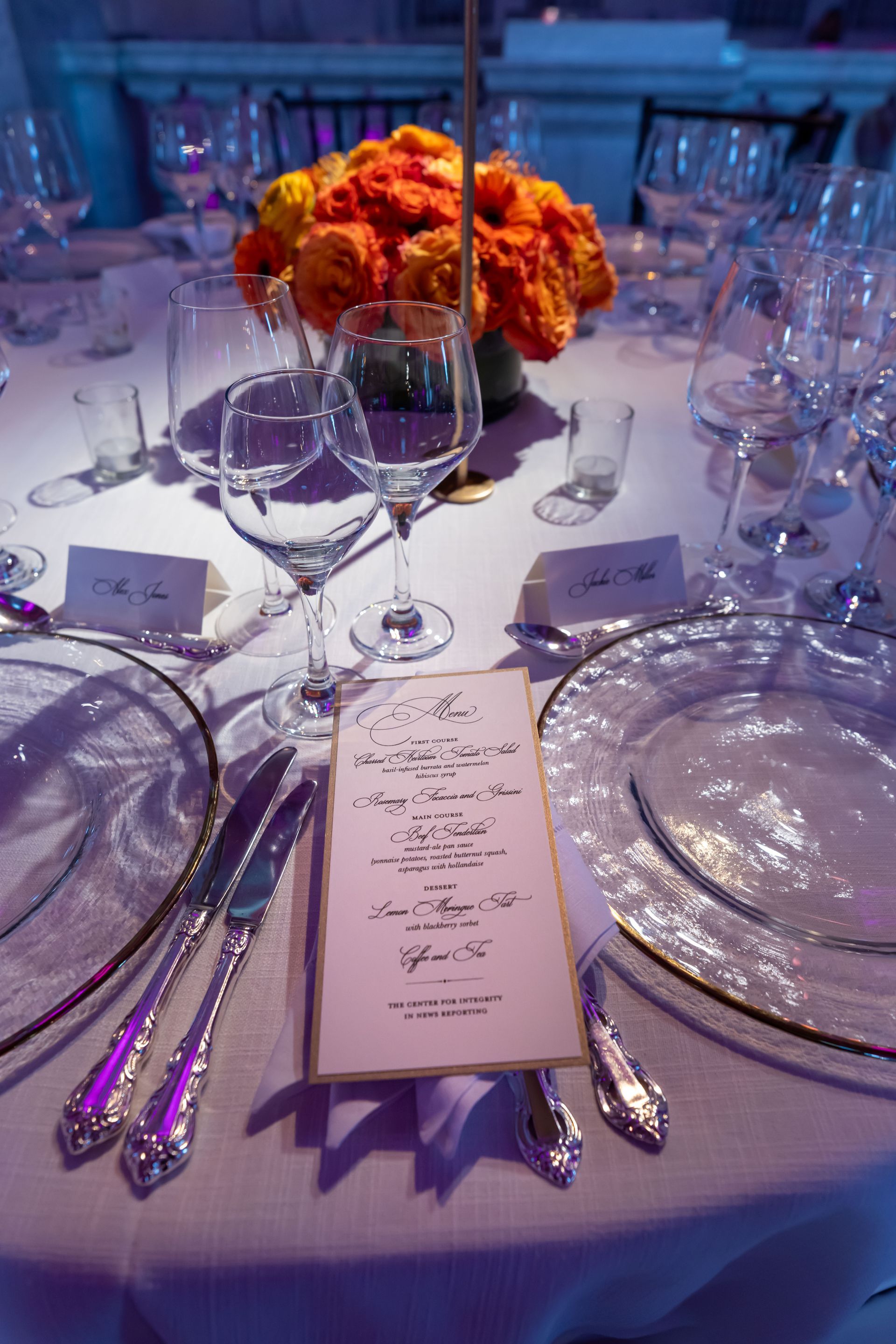 A table with plates , utensils , and a menu on it.