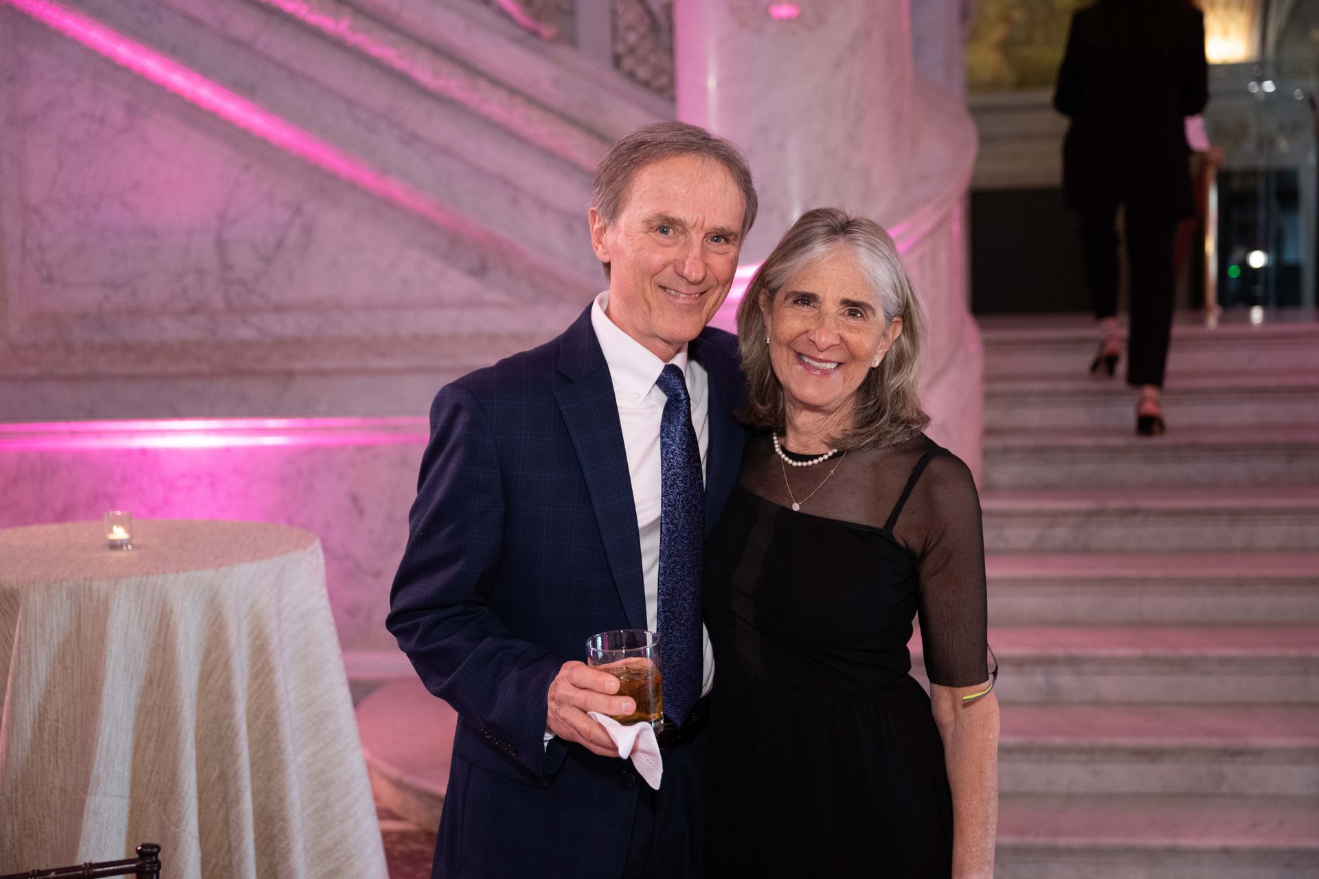 A man and a woman are posing for a picture at a party.