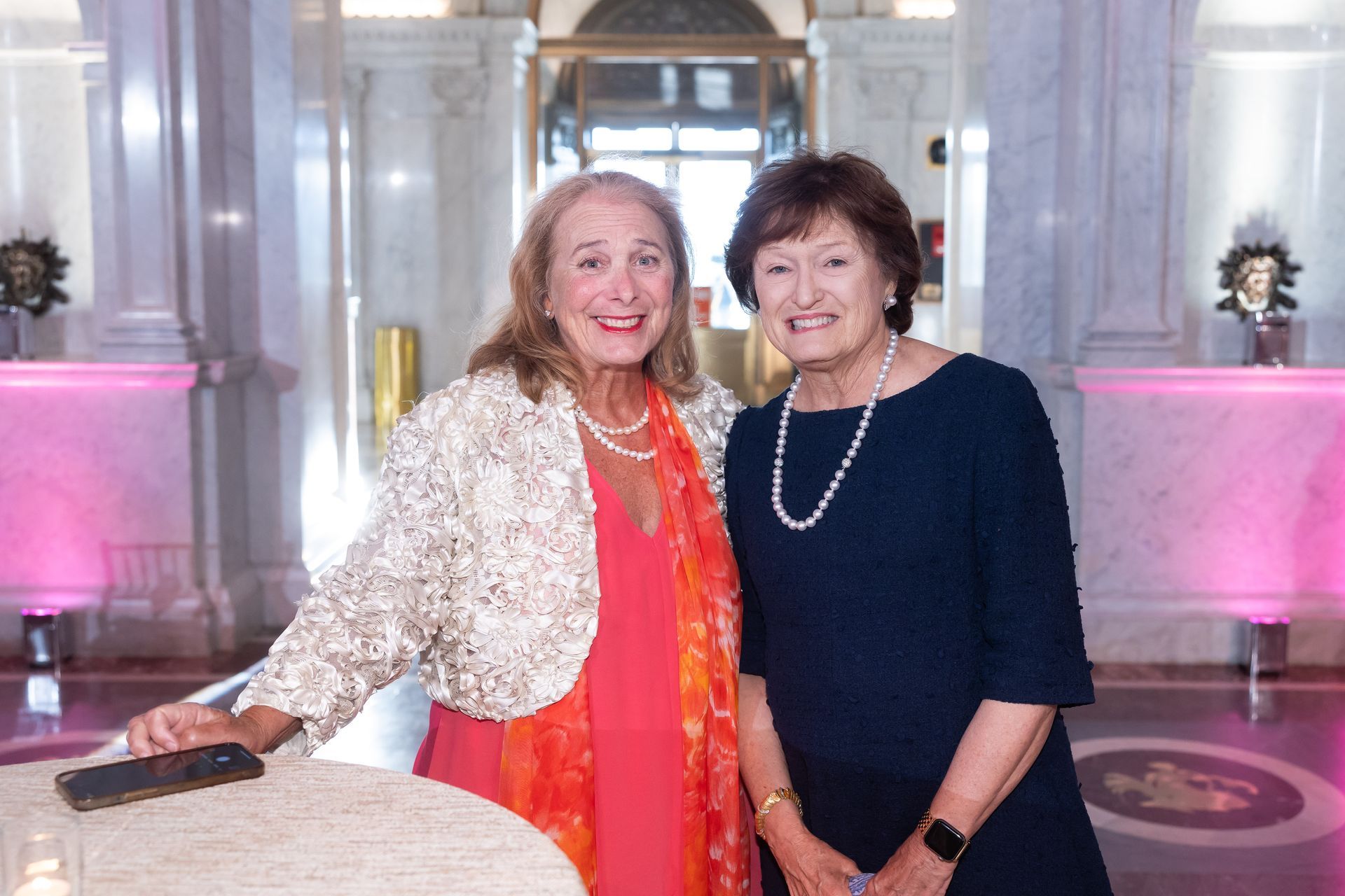 Two women are posing for a picture together in a room.