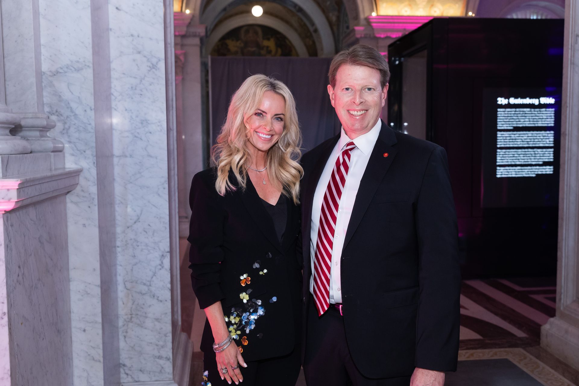 A man and a woman are posing for a picture in a hallway.