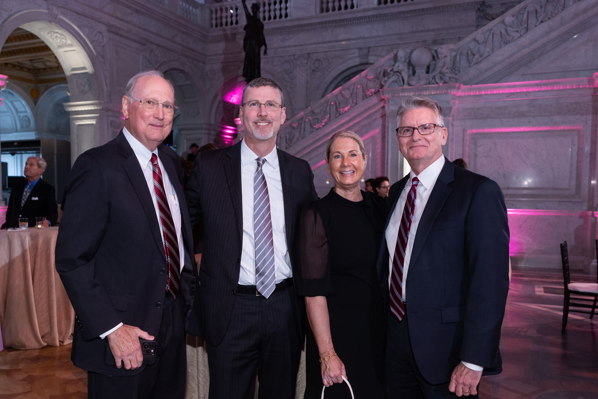 A group of people in suits and ties are posing for a picture in a room.