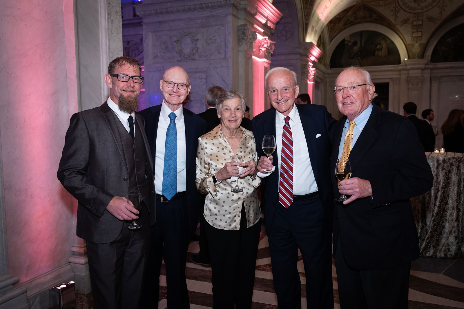 A group of people in suits and ties are posing for a picture.