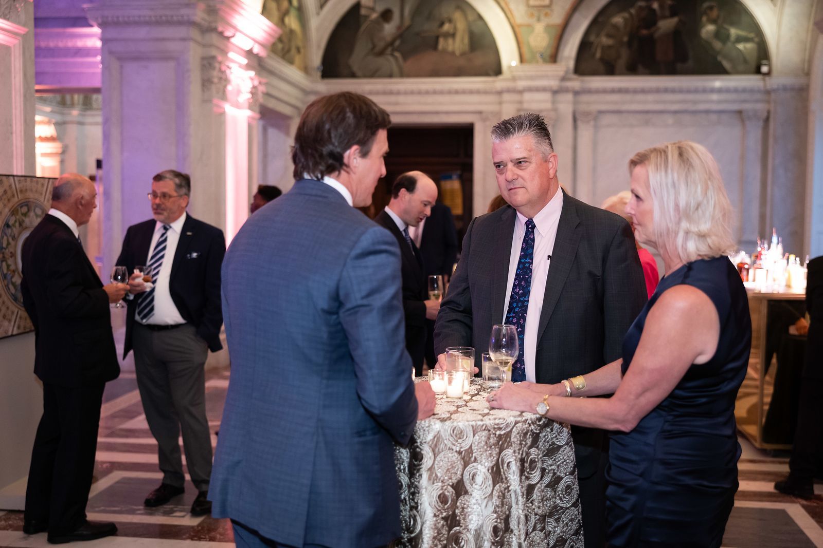 A group of people are standing around a table in a room.