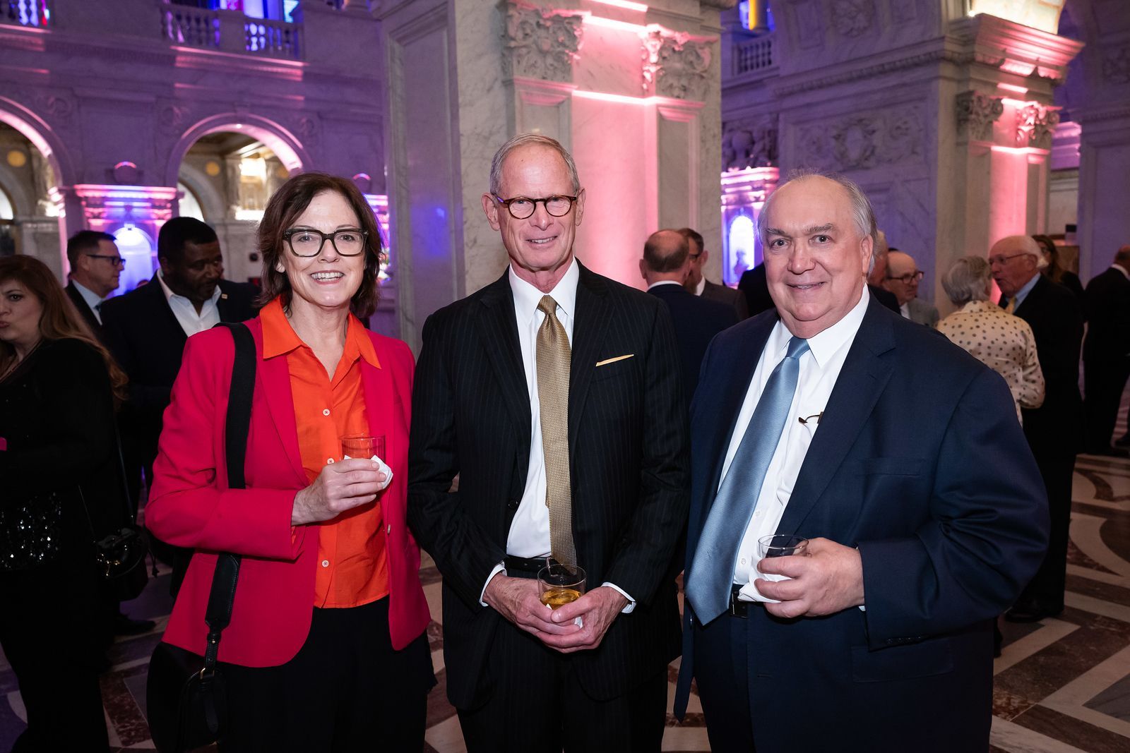 A group of people are standing next to each other in a room.