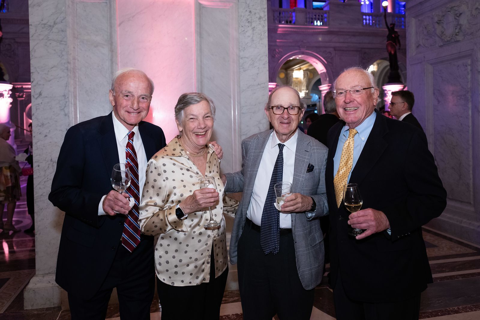 A group of people standing next to each other holding wine glasses.