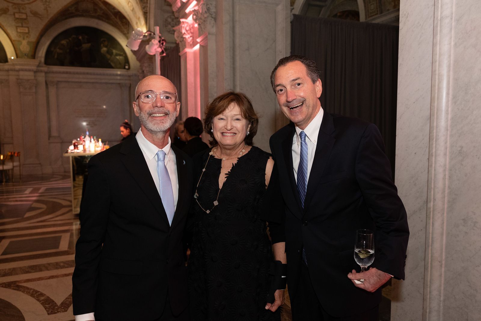 Two men and a woman are posing for a picture in a room.