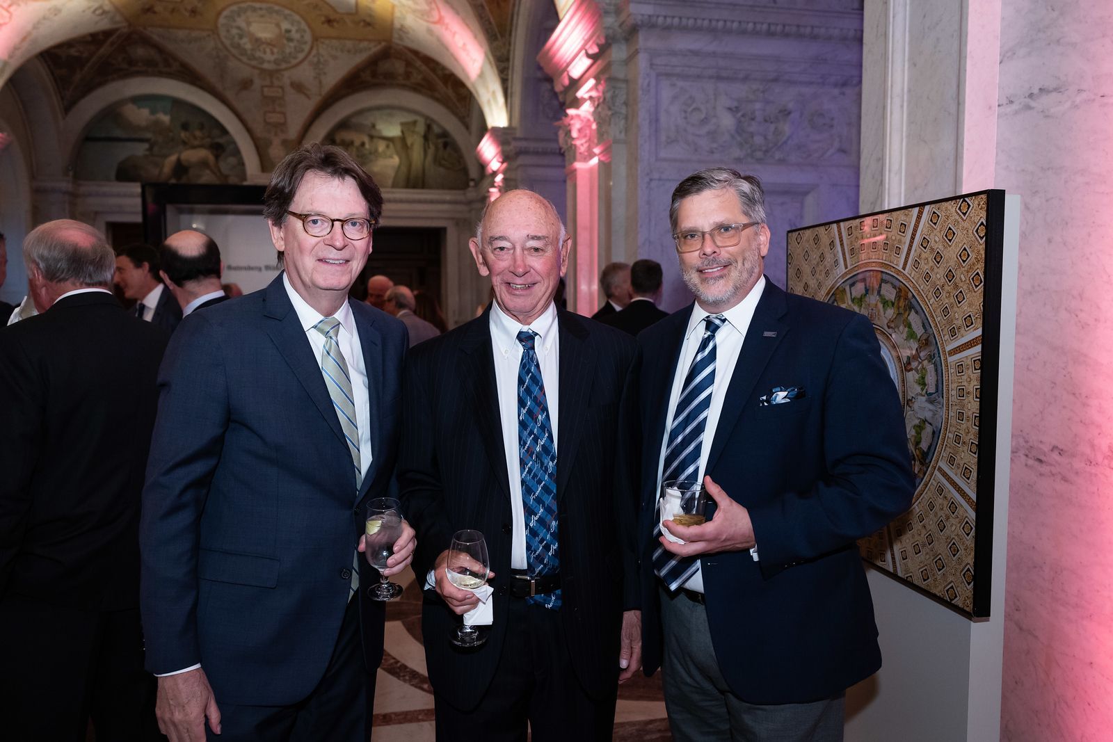 Three men in suits and ties are posing for a picture.