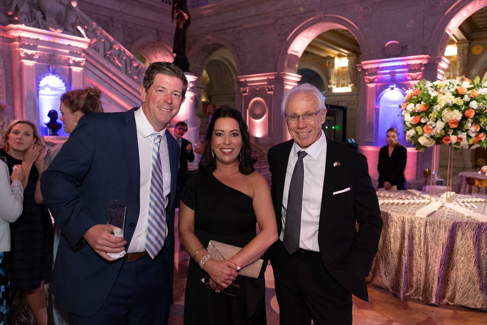 A man in a suit and tie is standing next to a woman in a black dress.