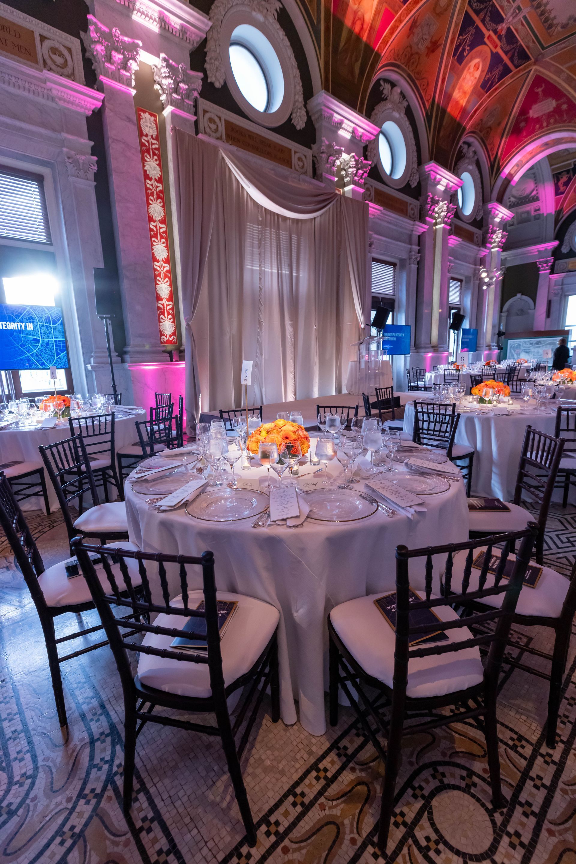A large room with tables and chairs set up for a wedding reception.
