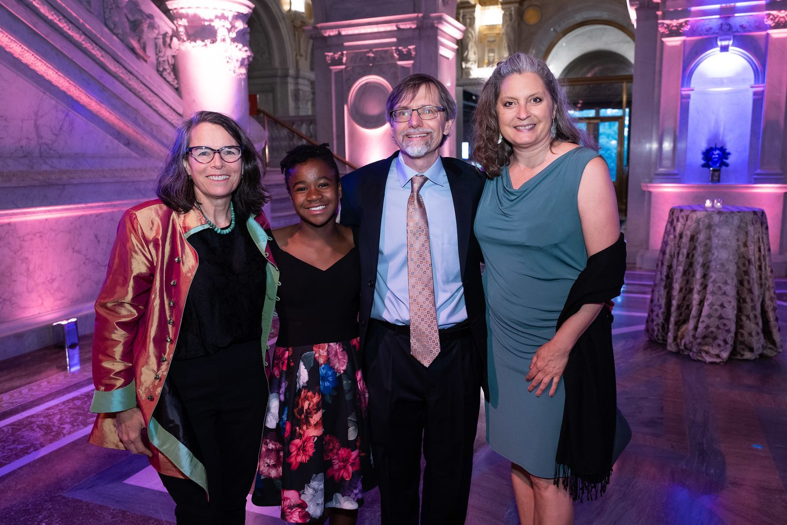 A group of people are posing for a picture in a hallway.