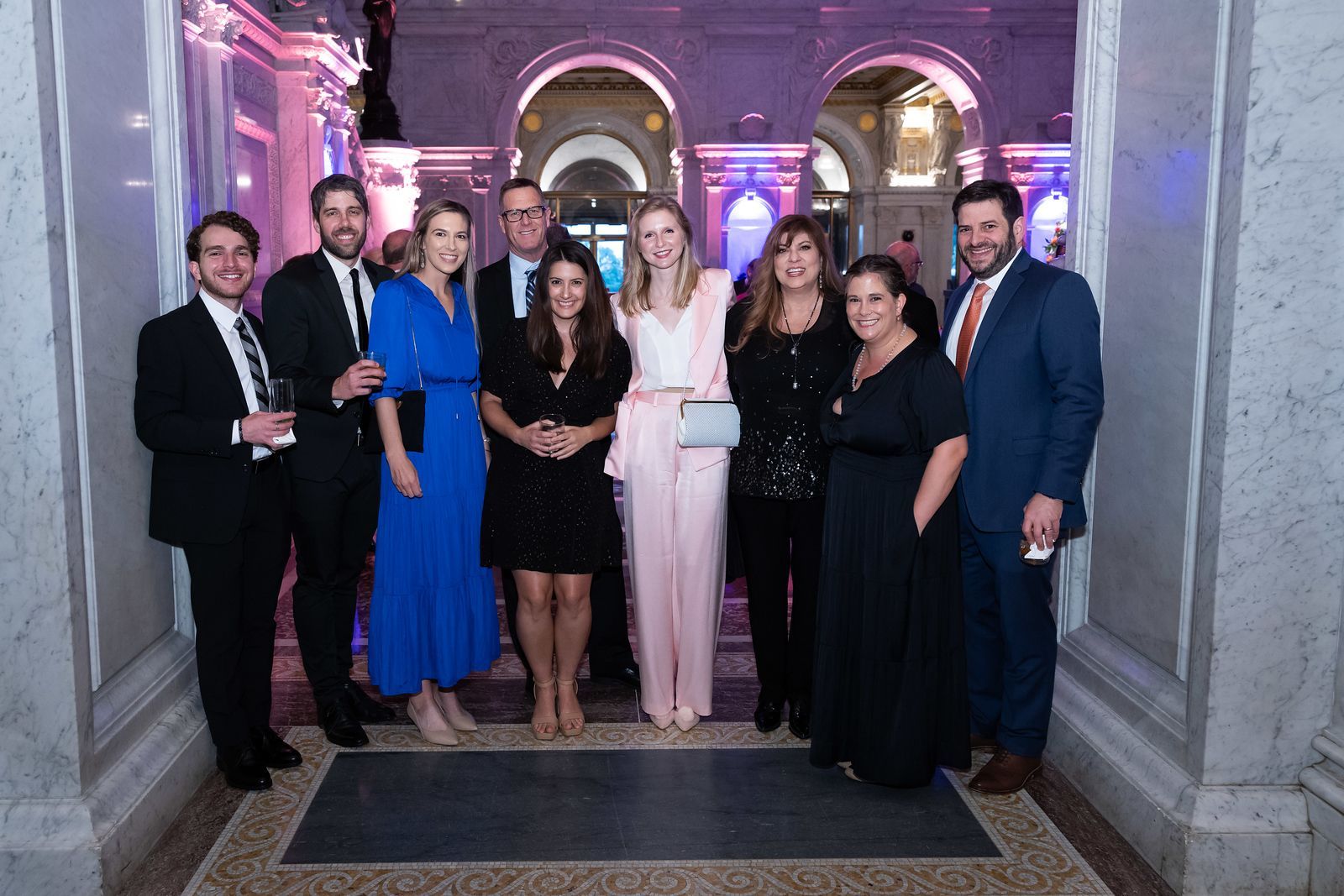 A group of people are posing for a picture in a hallway.