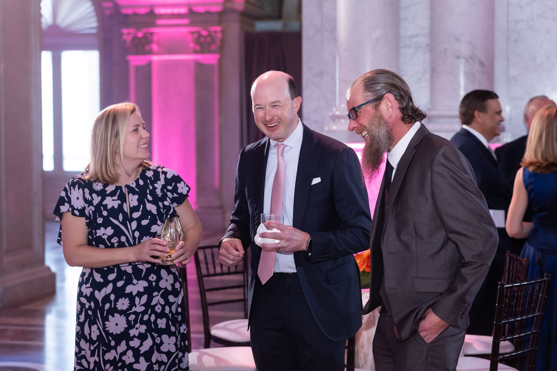 A group of people are standing in a room talking to each other.