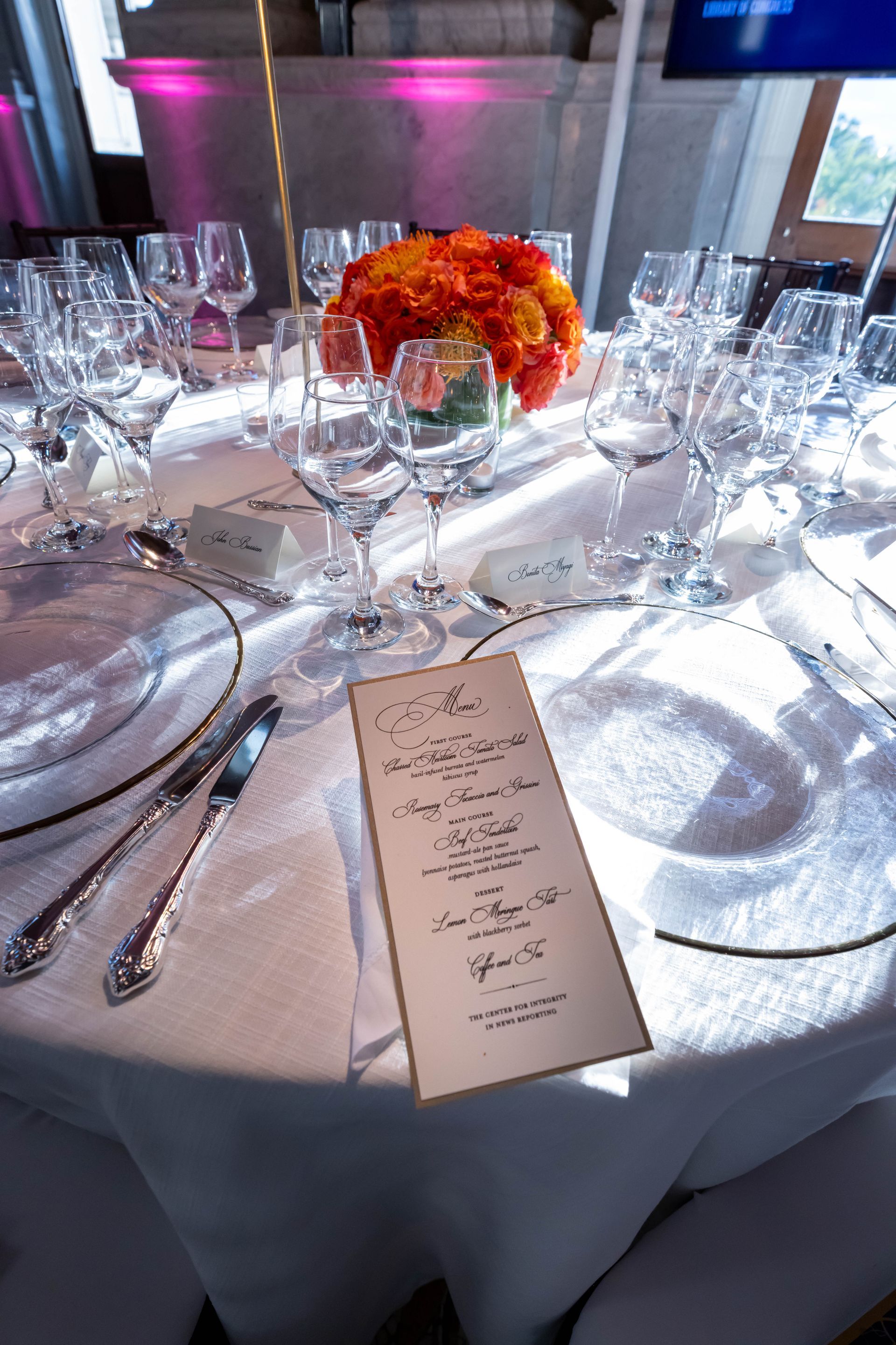 A table set for a wedding reception with a menu on it.