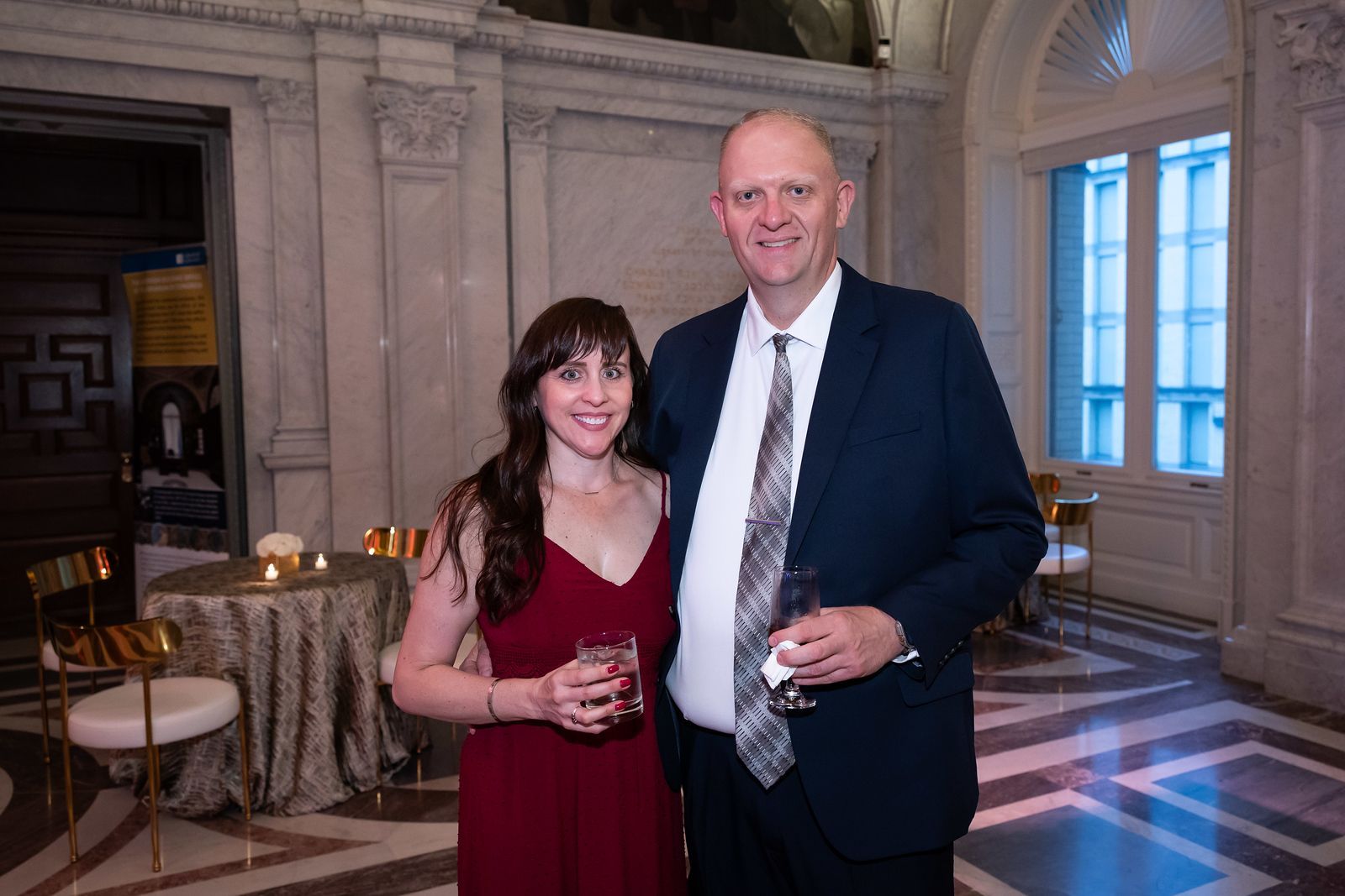 A man and a woman are posing for a picture in a room.