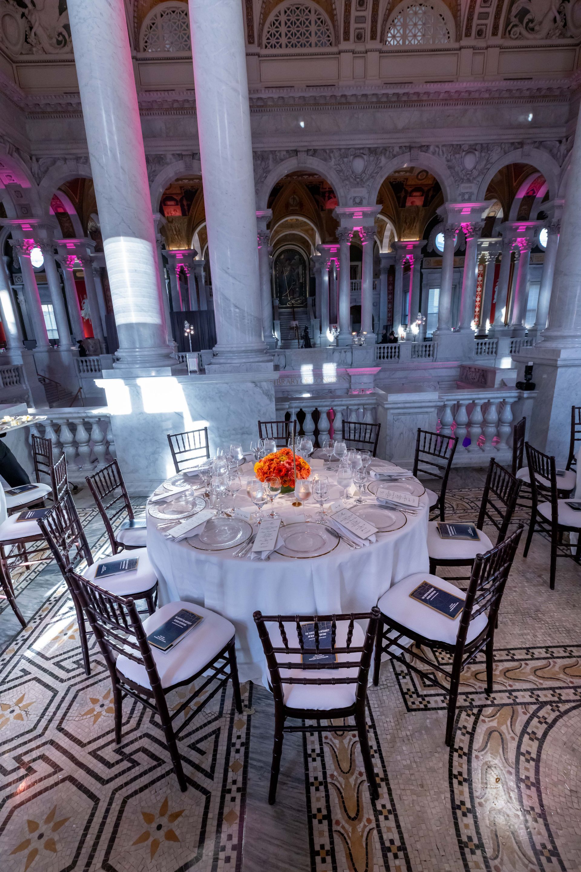 A large room with tables and chairs set up for a party.
