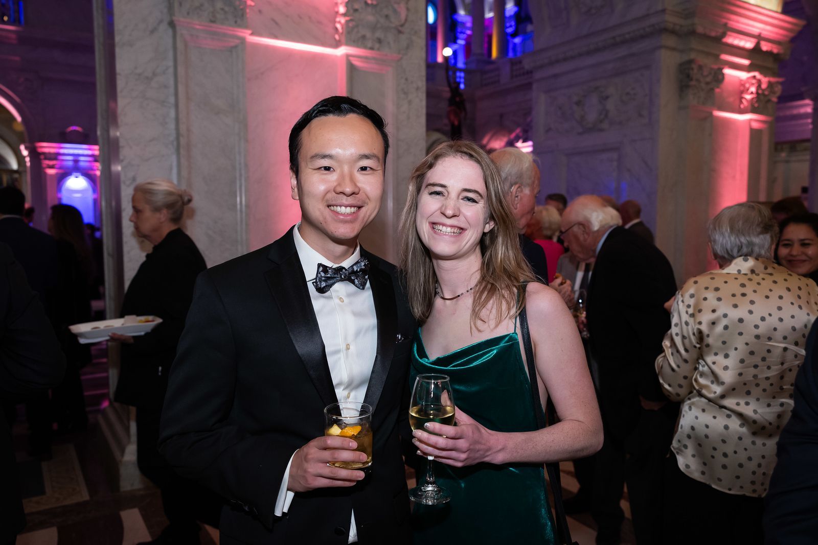 A man and a woman are posing for a picture at a party.