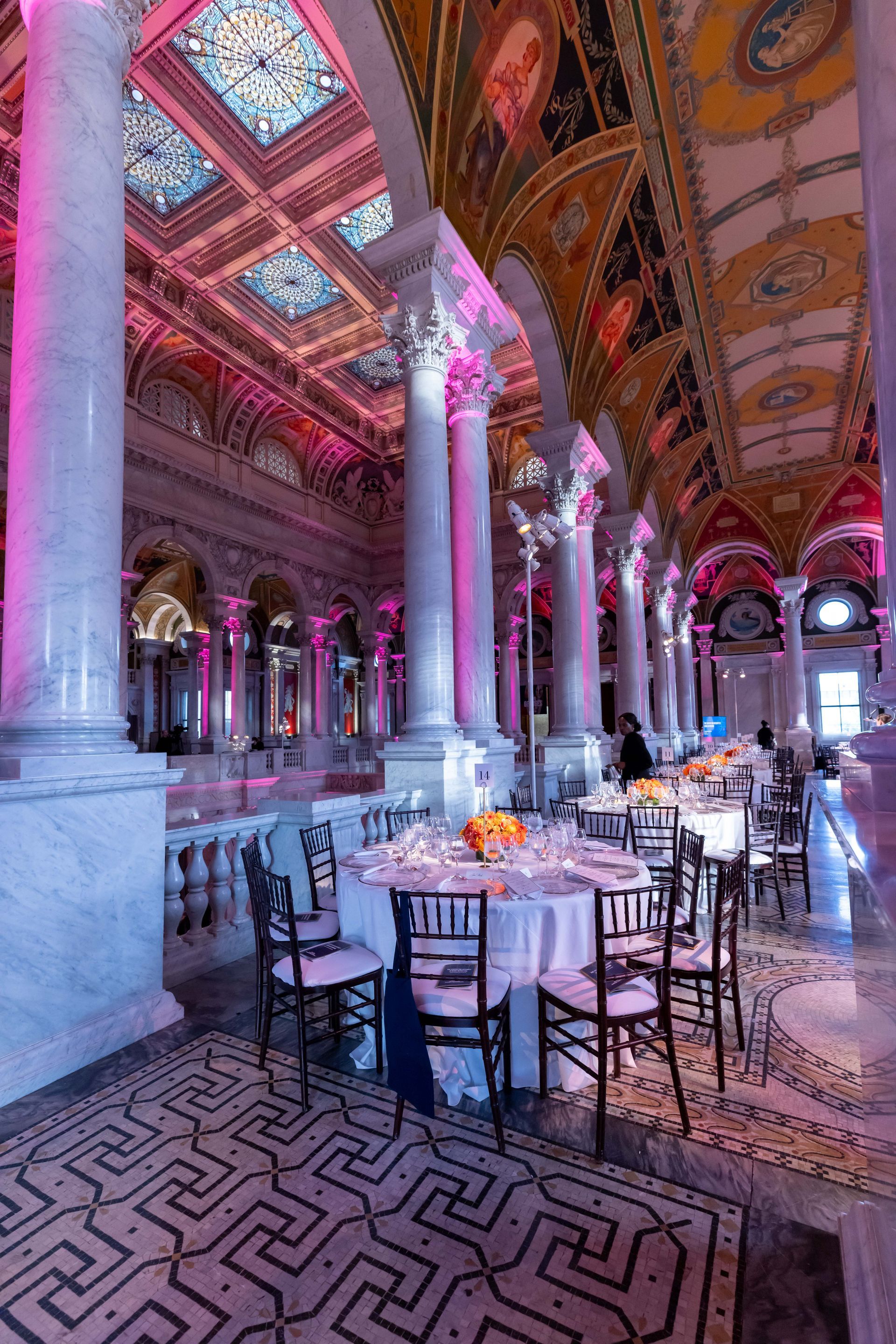 A large room with tables and chairs set up for a party.