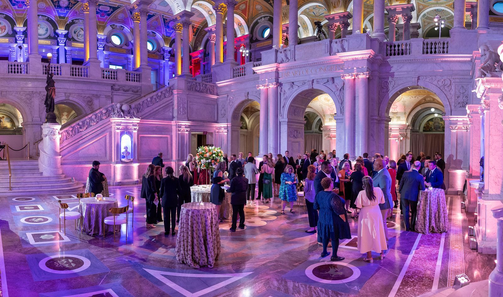 A large group of people are standing in a large room.