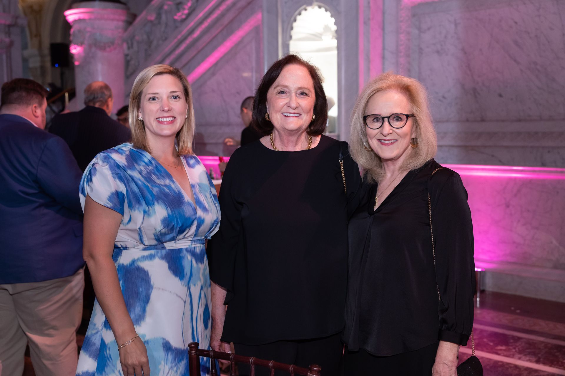 Three women are posing for a picture together in a room.