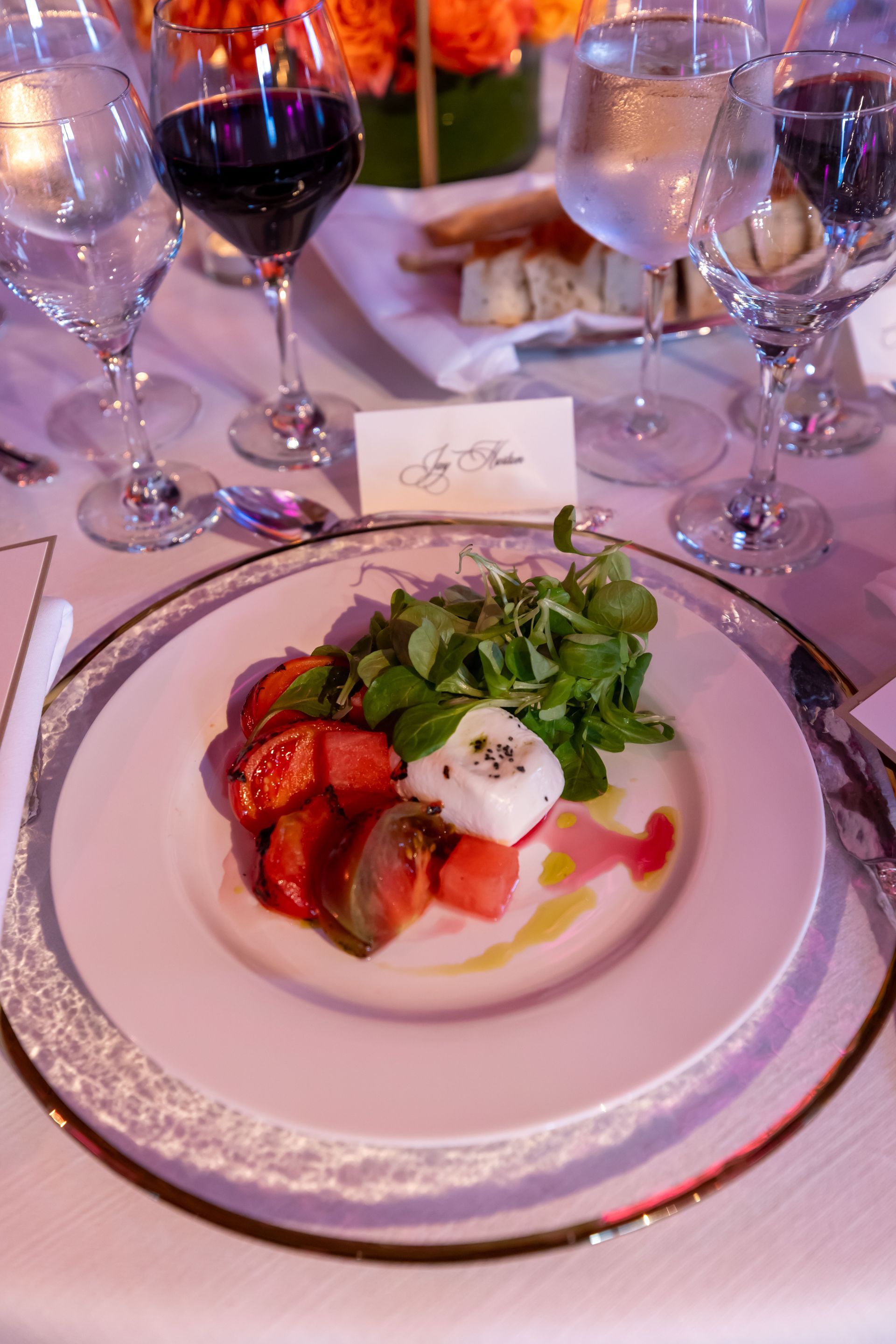 A plate of food is on a table next to wine glasses.