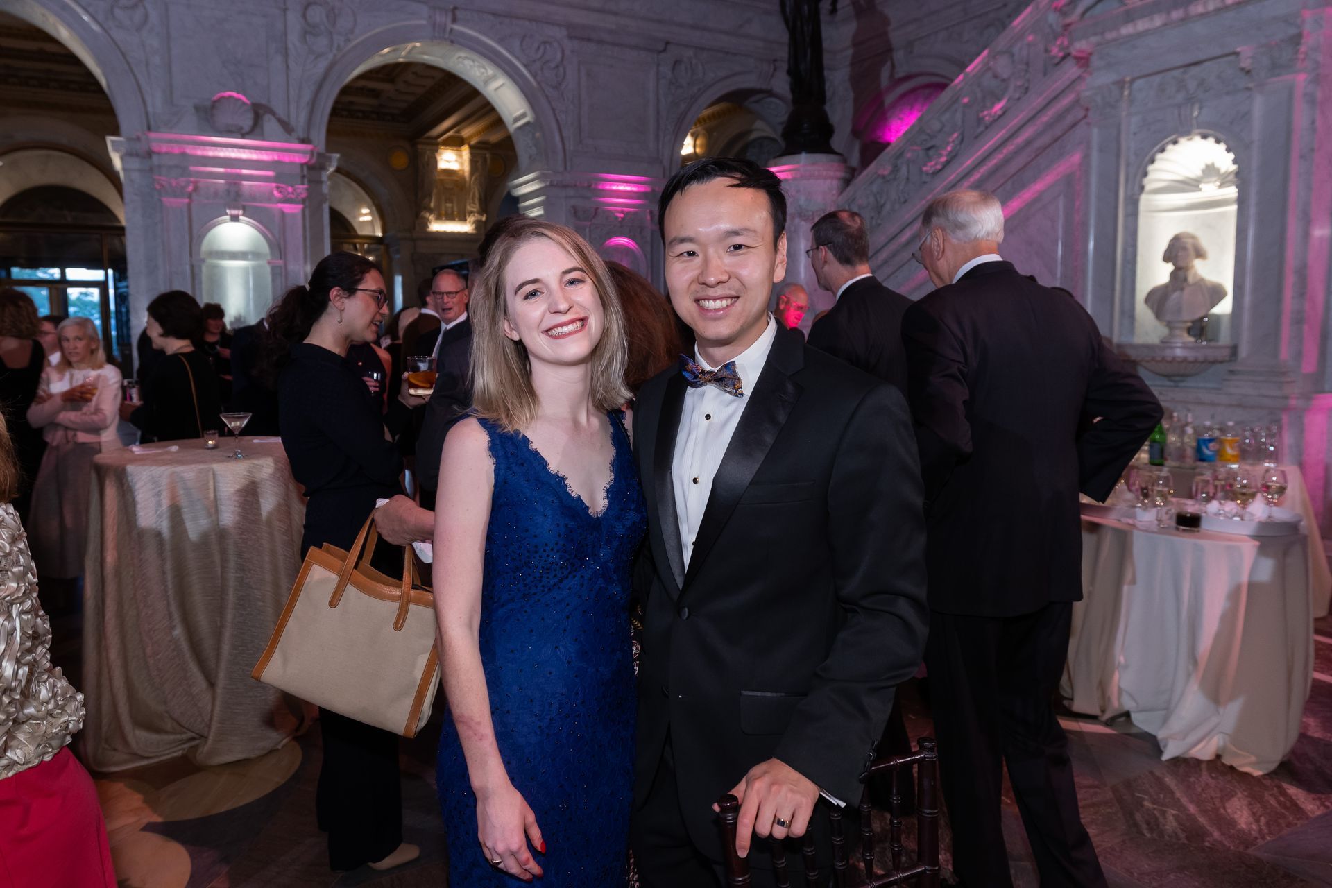 A man and a woman are posing for a picture at a party.