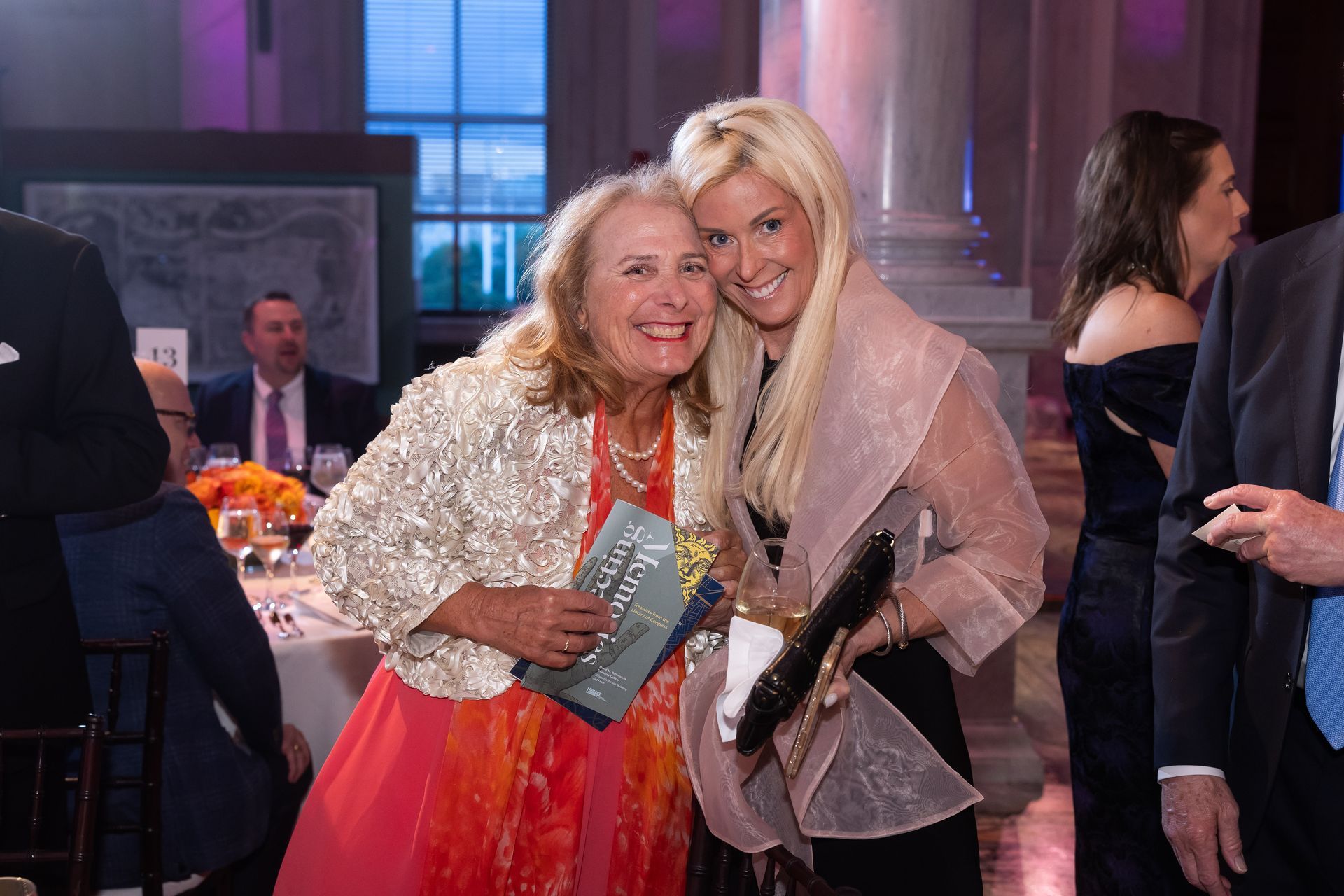 Two women are posing for a picture at a party.