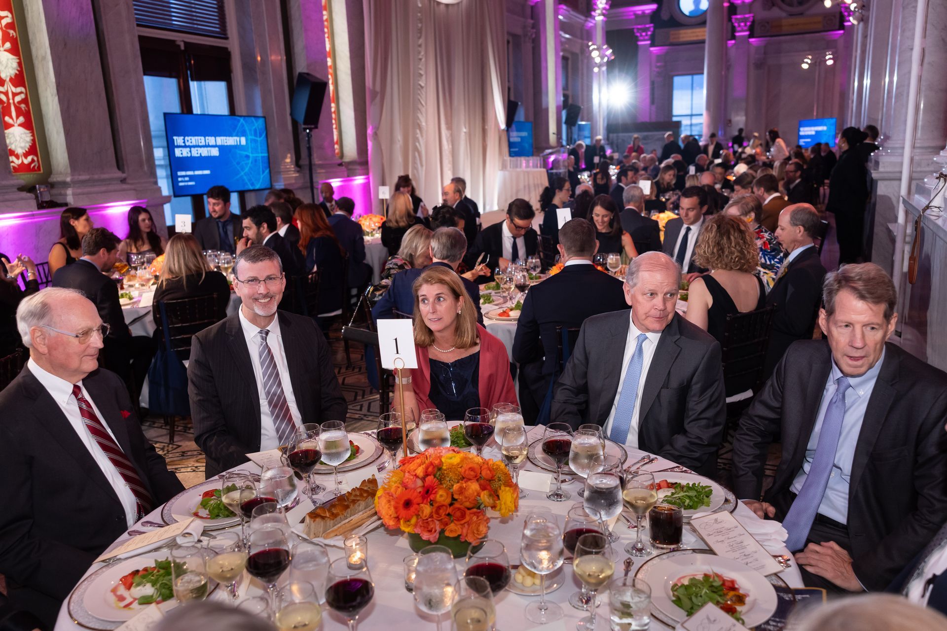 A group of people are sitting at a table at a dinner party.