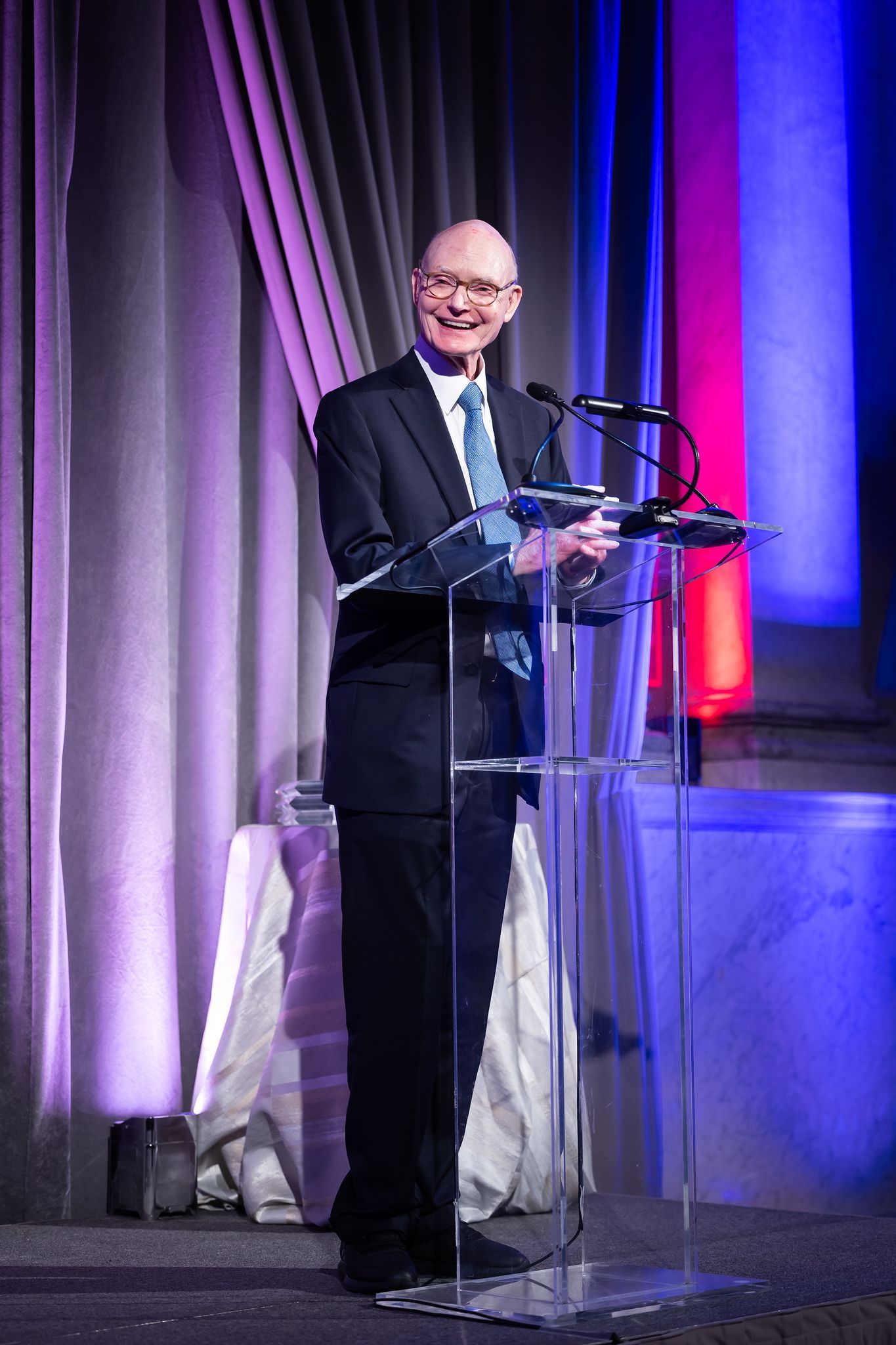 A man in a suit and tie is standing at a podium giving a speech.